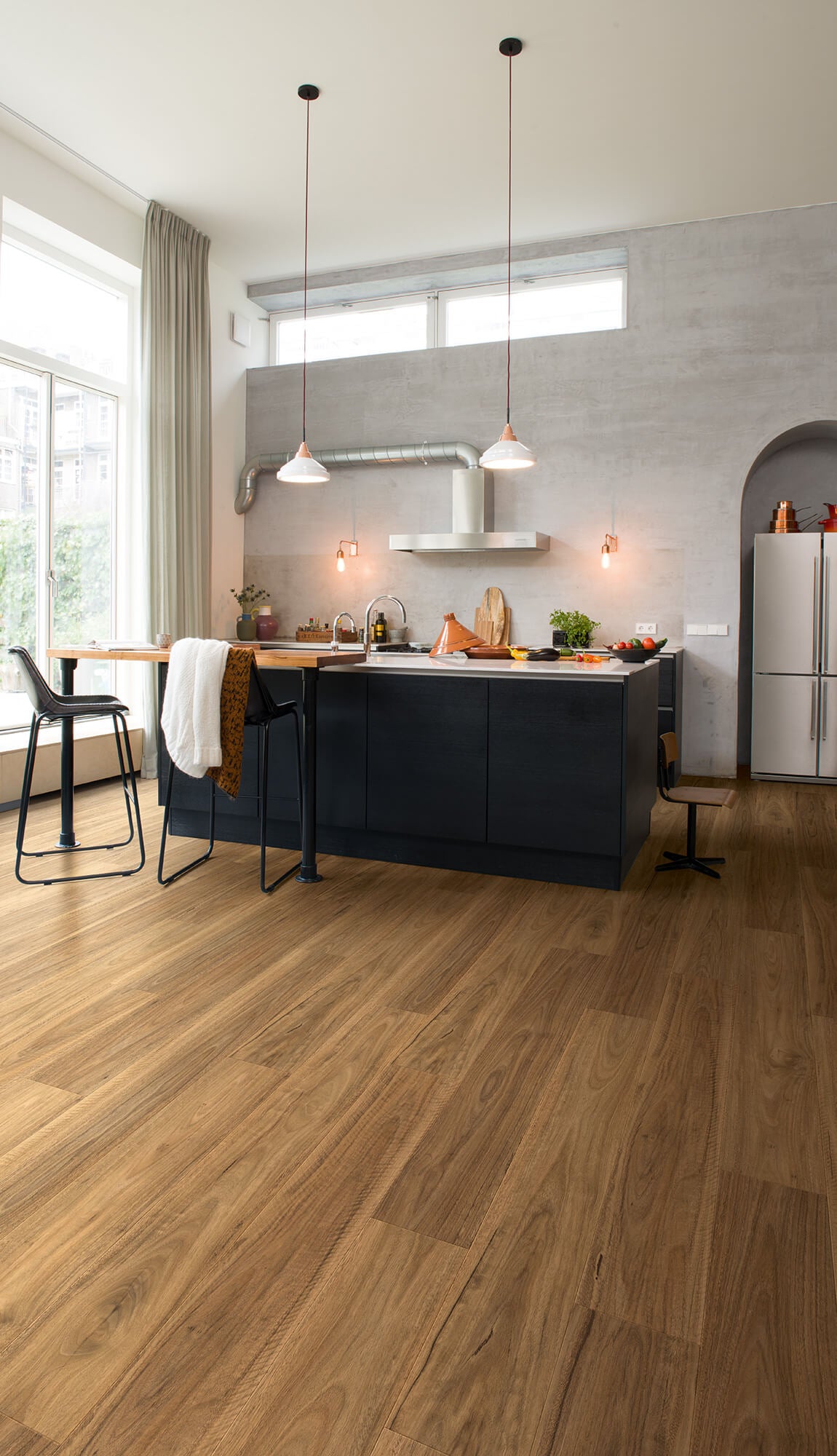Modern kitchen with wooden flooring and gray walls.
