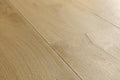 Light oak wood flooring planks with visible natural grain patterns and subtle seams.