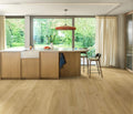 Modern kitchen with wooden cabinets, island, and stools near large windows.