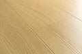 Light beige wood-look flooring planks with a natural oak grain texture.
