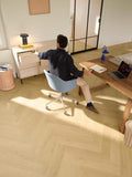 Person sitting at a wooden desk in a modern office setting
