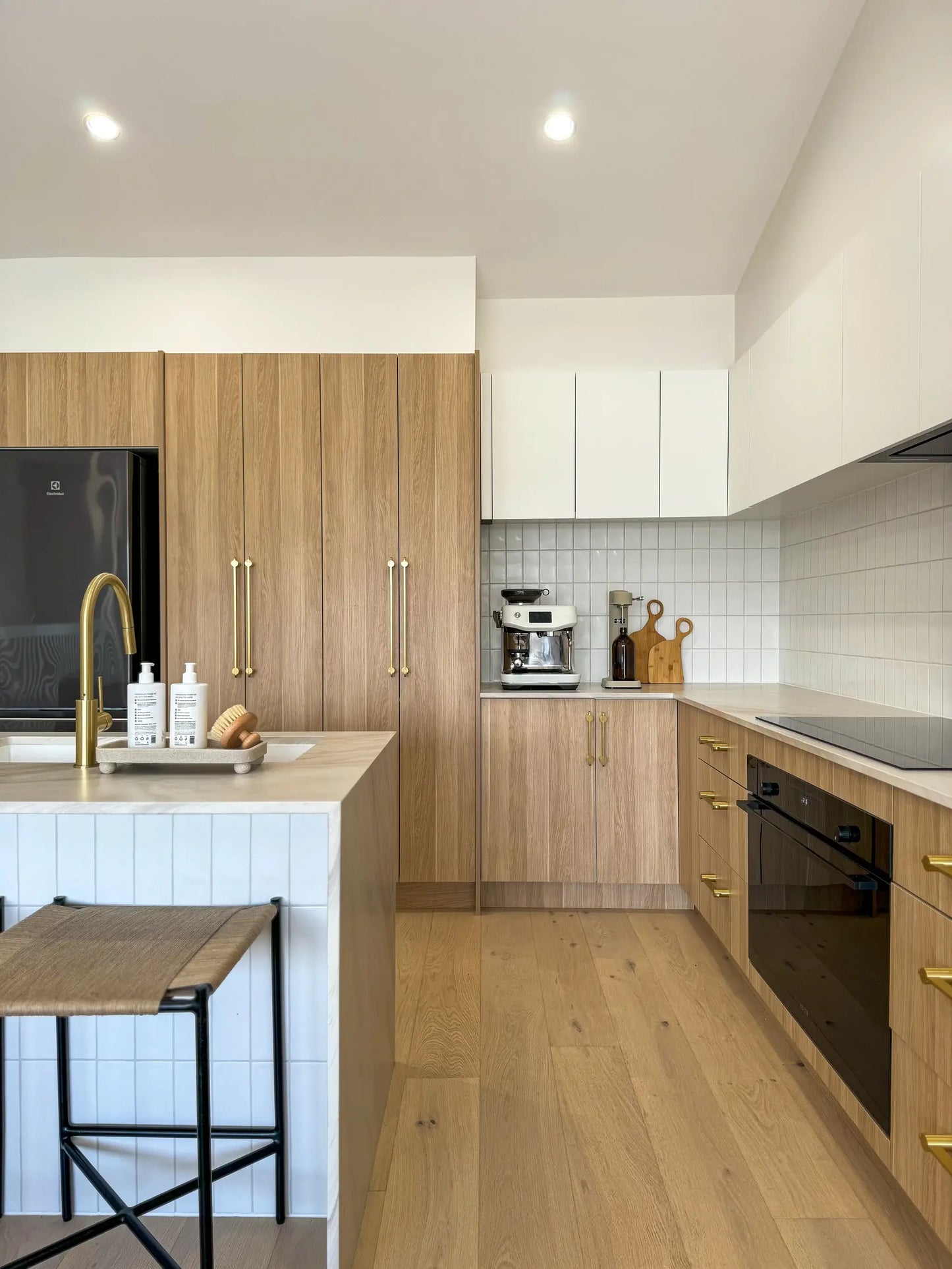 Modern kitchen with wooden cabinets, white countertops, and stainless steel appliances.