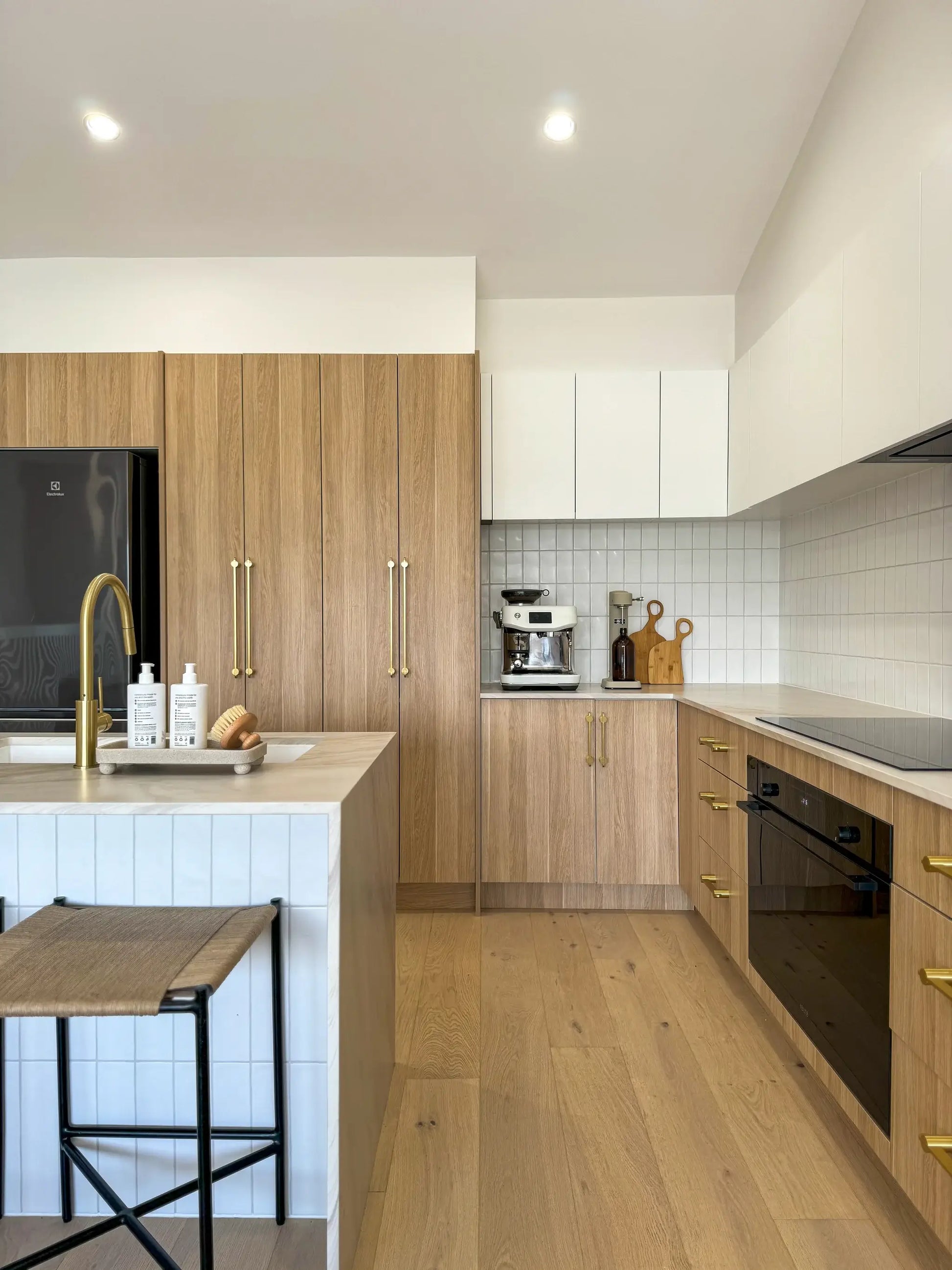 Modern kitchen with wooden cabinets, white countertops, and stainless steel appliances.