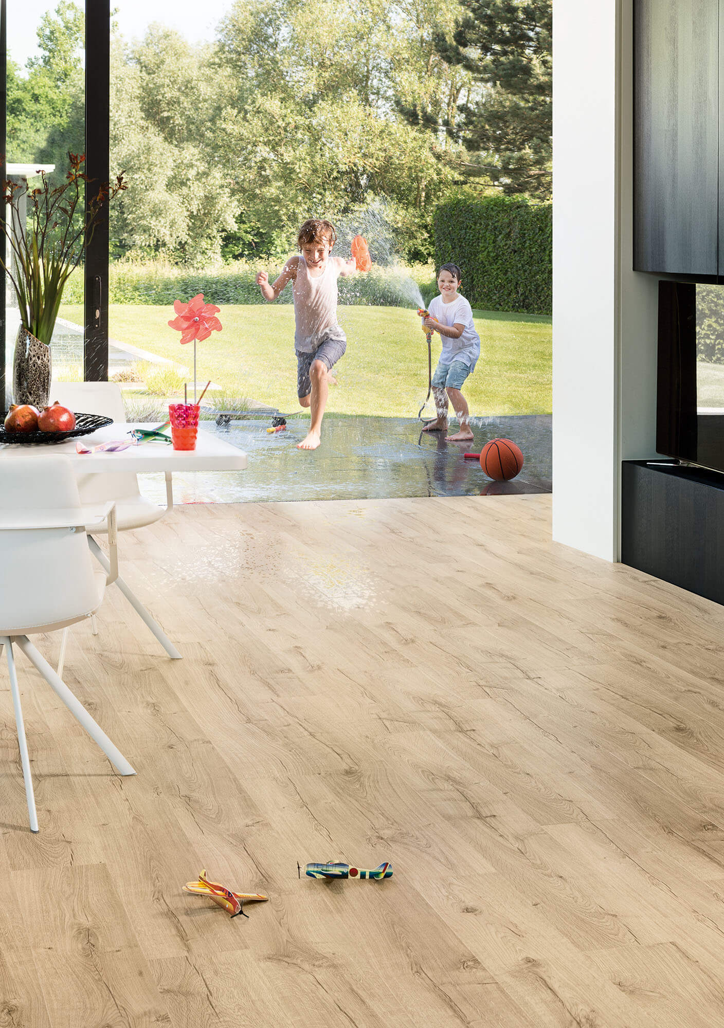 Children playing in a modern living room with wooden flooring.