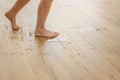 Person walking on a wooden floor with water stains