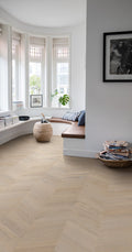 Living room with wooden flooring, windows, and decorative items.