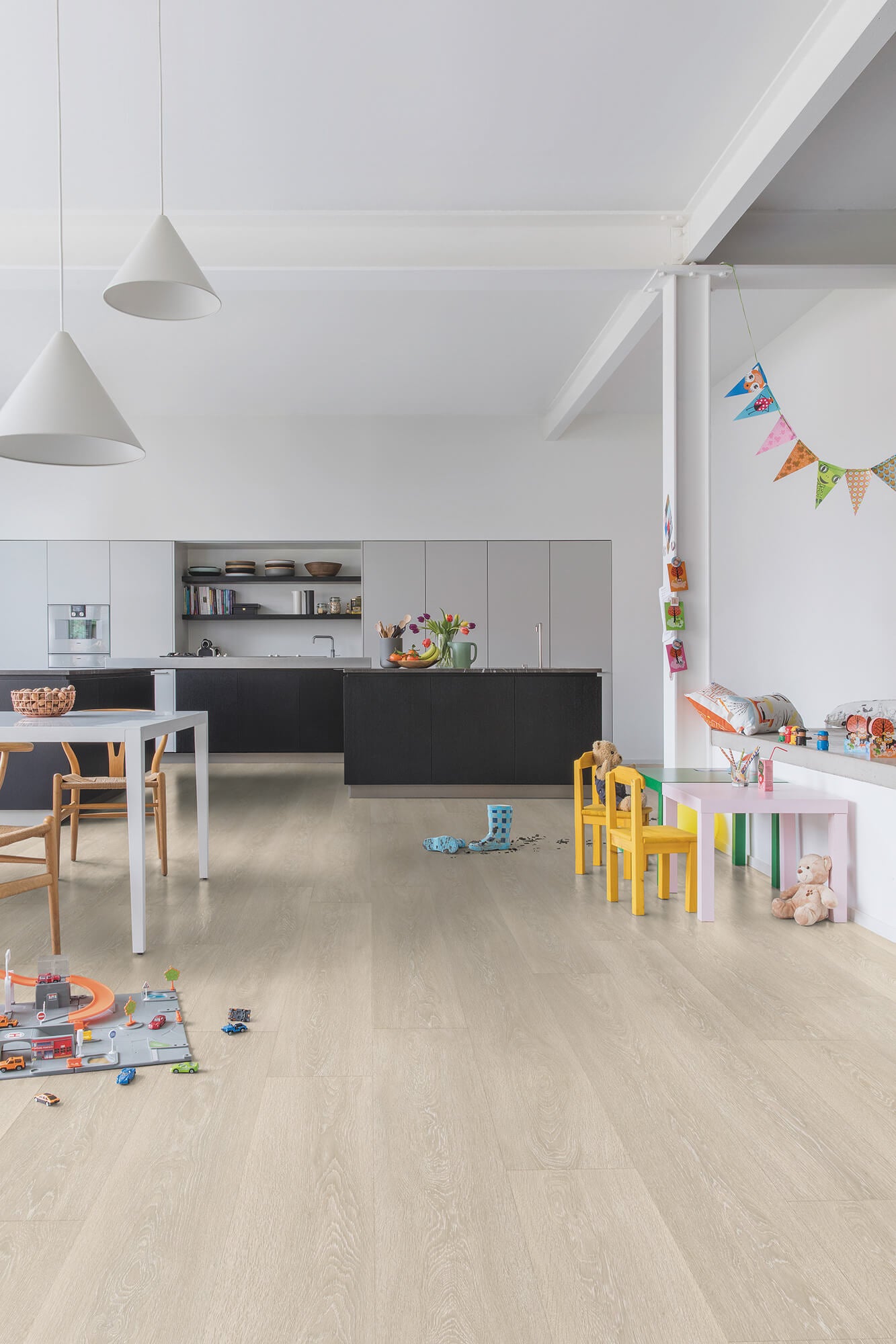 Modern kitchen with light wood flooring and children's toys scattered around.