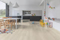 Modern kitchen with wooden floor and children's toys scattered around
