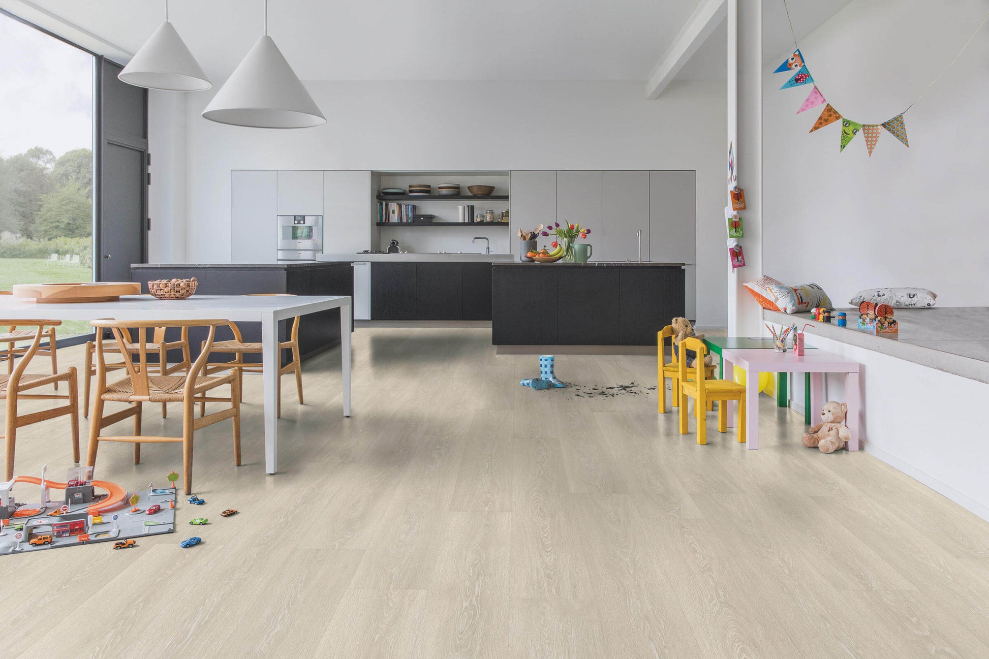 Modern kitchen with wooden floor and children's toys scattered around