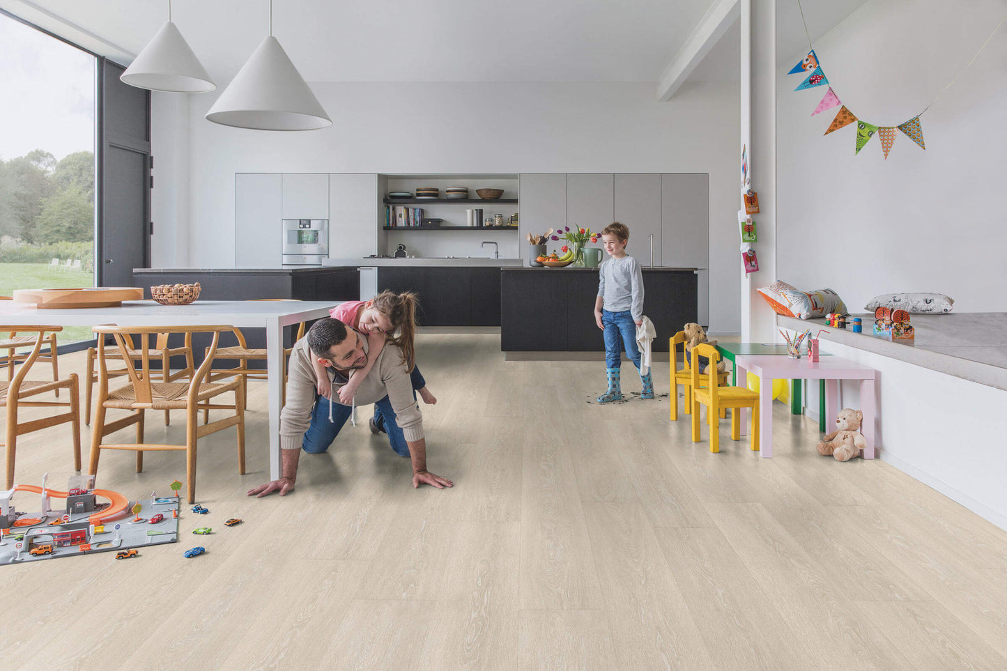 Family playing on a wooden floor in a modern kitchen