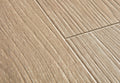 Close-up of beige ceramic tiles with a herringbone pattern