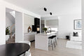Modern kitchen and living room with white walls and black fixtures