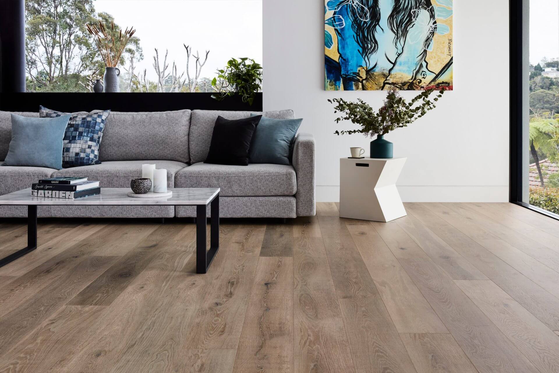Living room with gray sofa, wooden floor, and modern decor