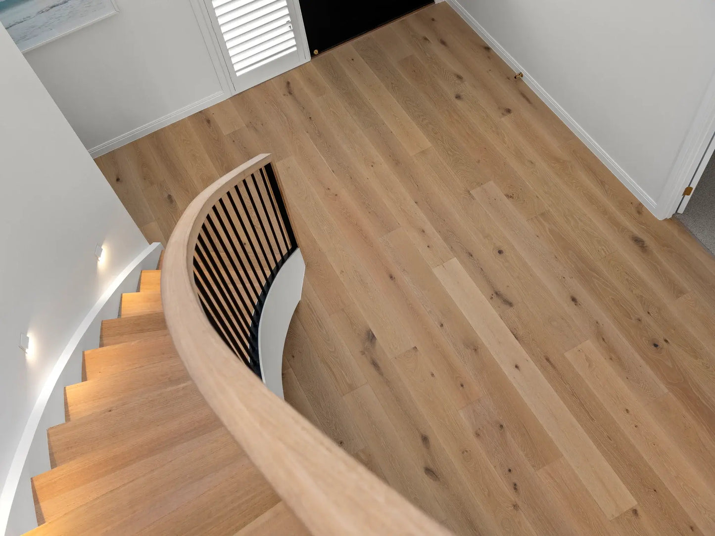 Wooden staircase with a modern design in a well-lit room.