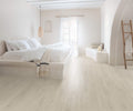 Minimalist bedroom with white walls, bed, and decor.