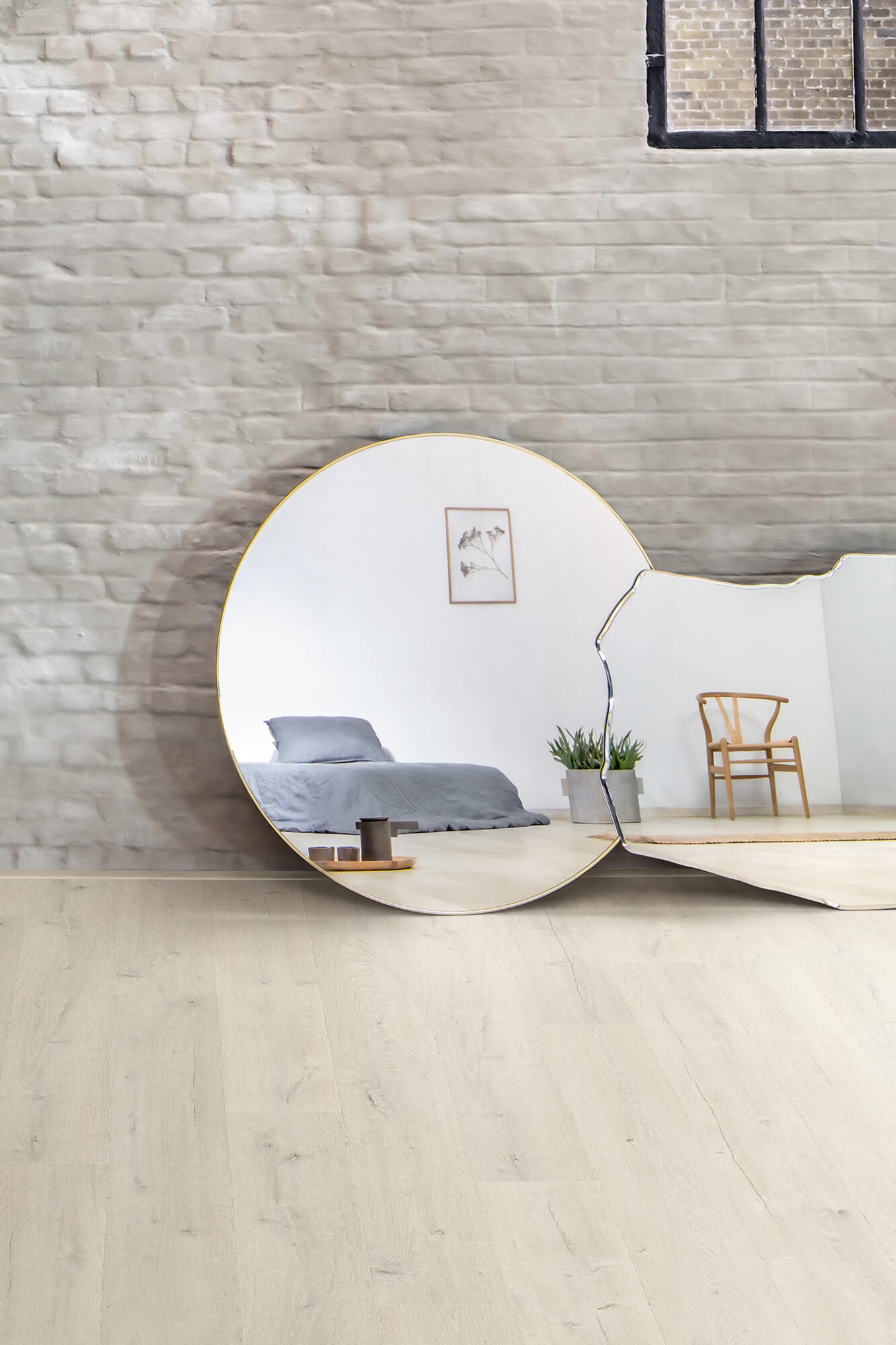 Modern interior design with round mirror reflecting a bedroom and chair.