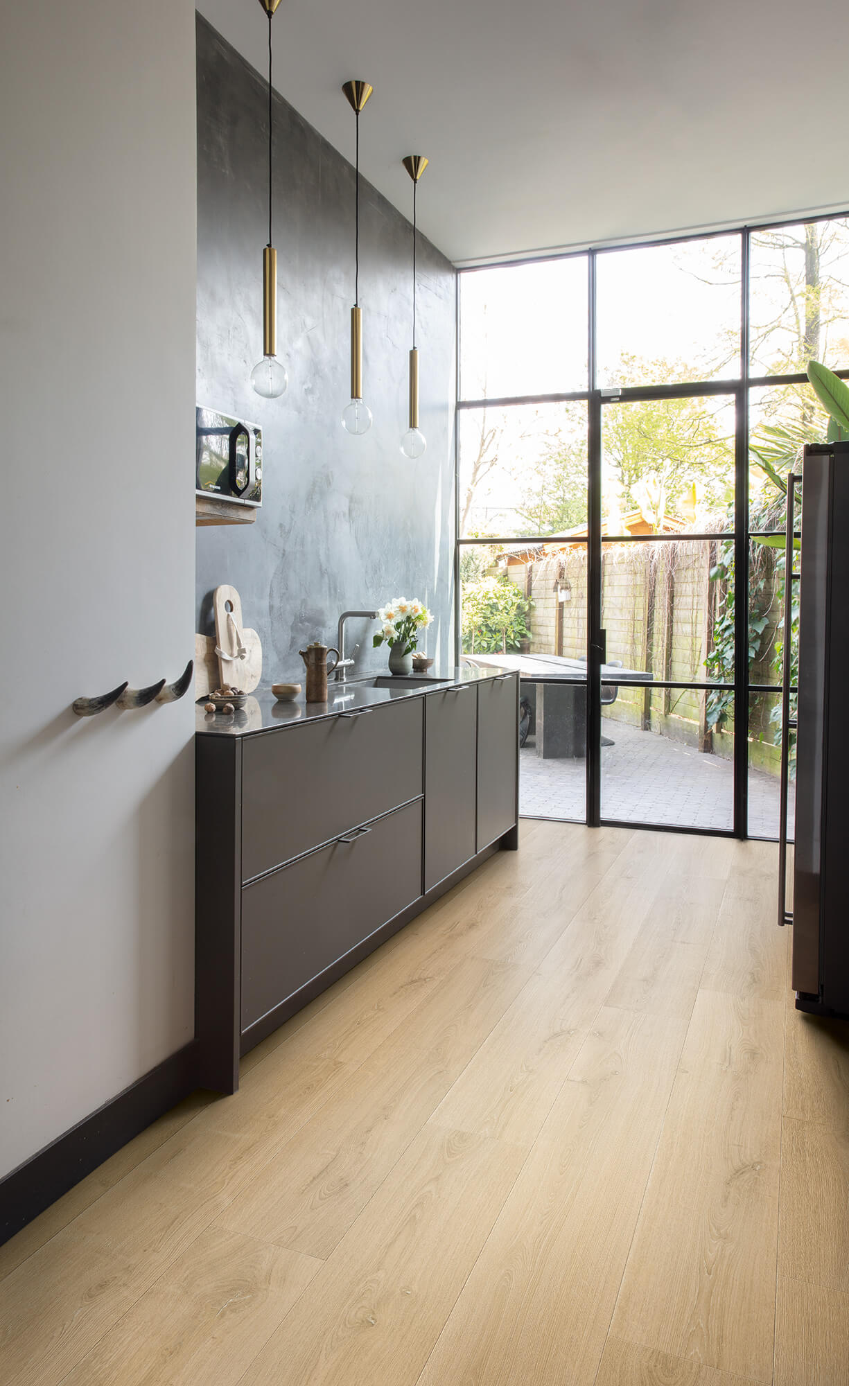 Modern kitchen with light wood flooring and large windows