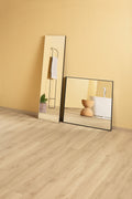 Two mirrors on a wooden floor with a beige wall background