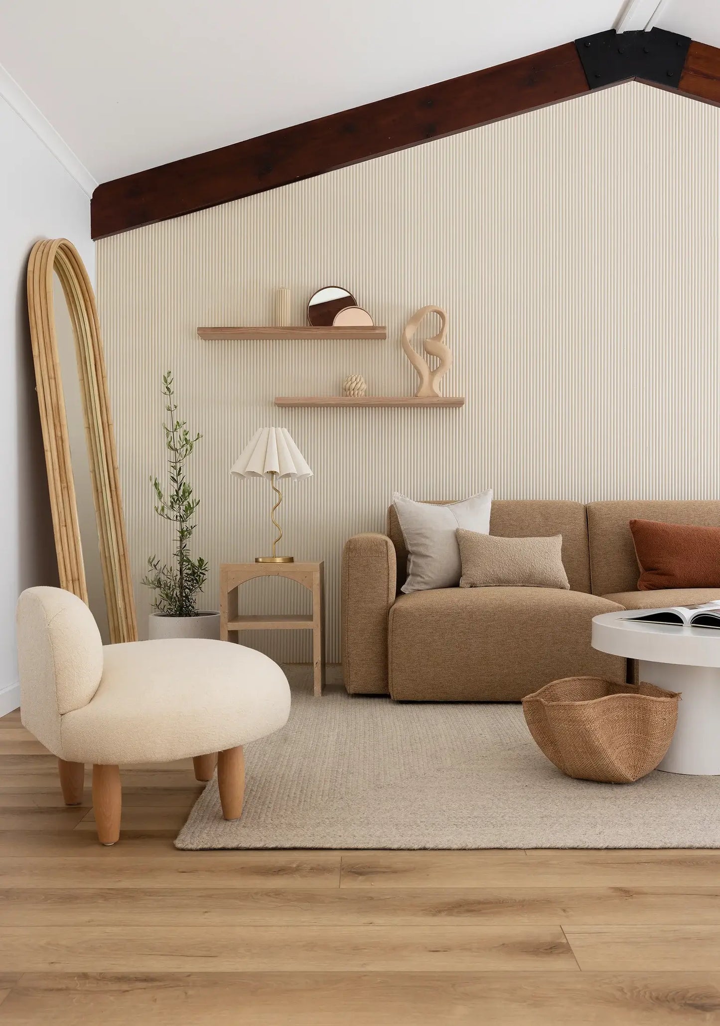 Modern living room with beige sofa, armchair, and decorative items.