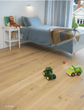 Children's bedroom with toys on a wooden floor, featuring a bed and nightstand.