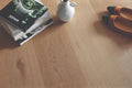 Wooden floor with a book, vase, and shoes on top