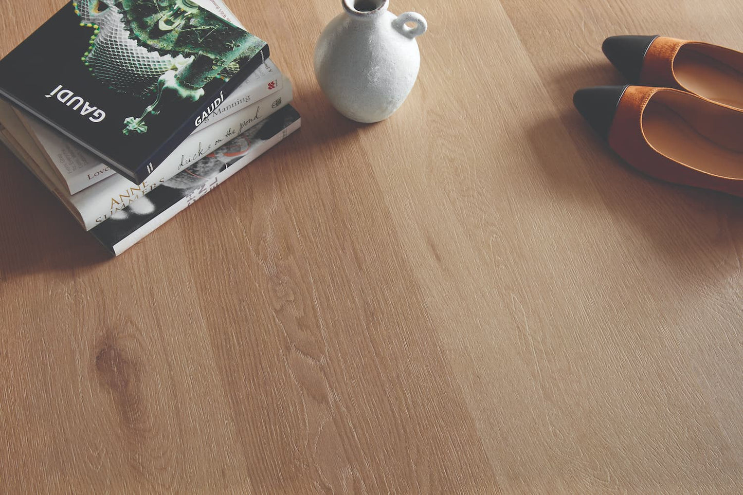 Wooden floor with a book, vase, and shoes on top