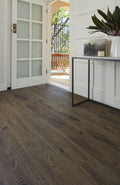 Wooden floor with a white wall and open door leading to a balcony.