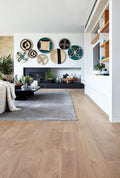 Modern living room with wooden flooring, decorative wall art, and a fireplace.