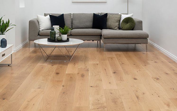 Living room with a gray sectional sofa, wooden coffee table, and light wood flooring.