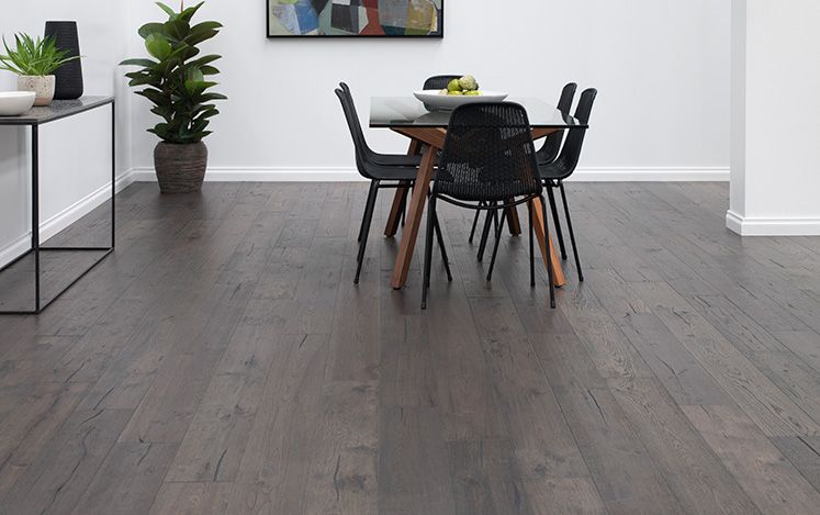 Dining area with a wooden table and chairs on a dark wood floor.