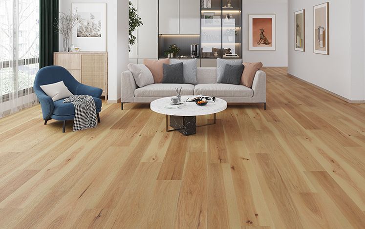 Modern living room with wooden flooring, gray sofa, and blue armchair.