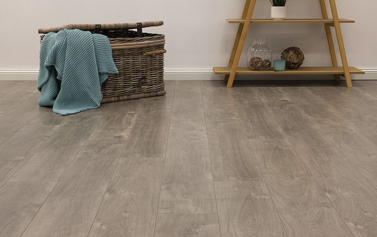 Wooden flooring with a woven basket and blue towel in a room.