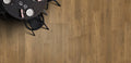 Wooden flooring with a black round table and chairs in the corner.