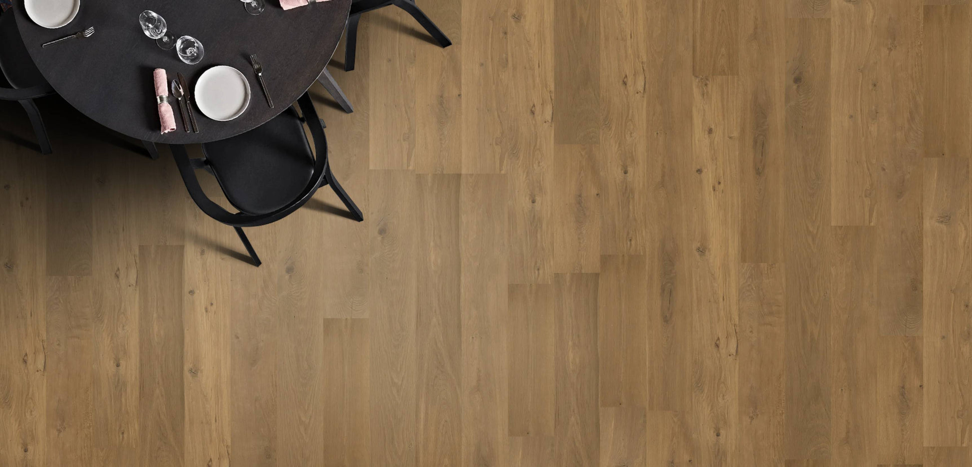 Wooden flooring with a black round table and chairs in the corner.