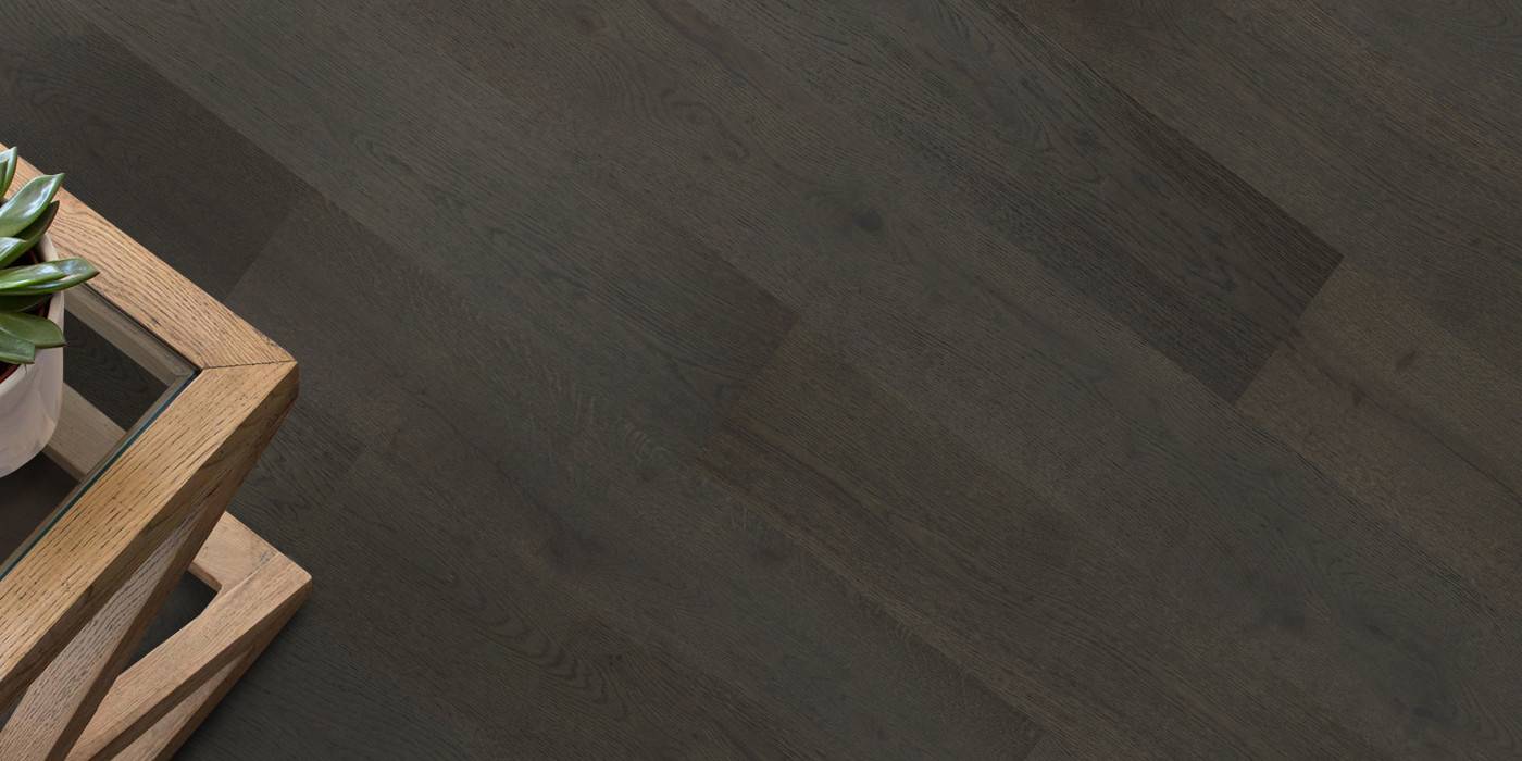 Dark wooden floor with a wooden side table and plant