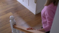 Person in a pink sweater standing on a wooden staircase