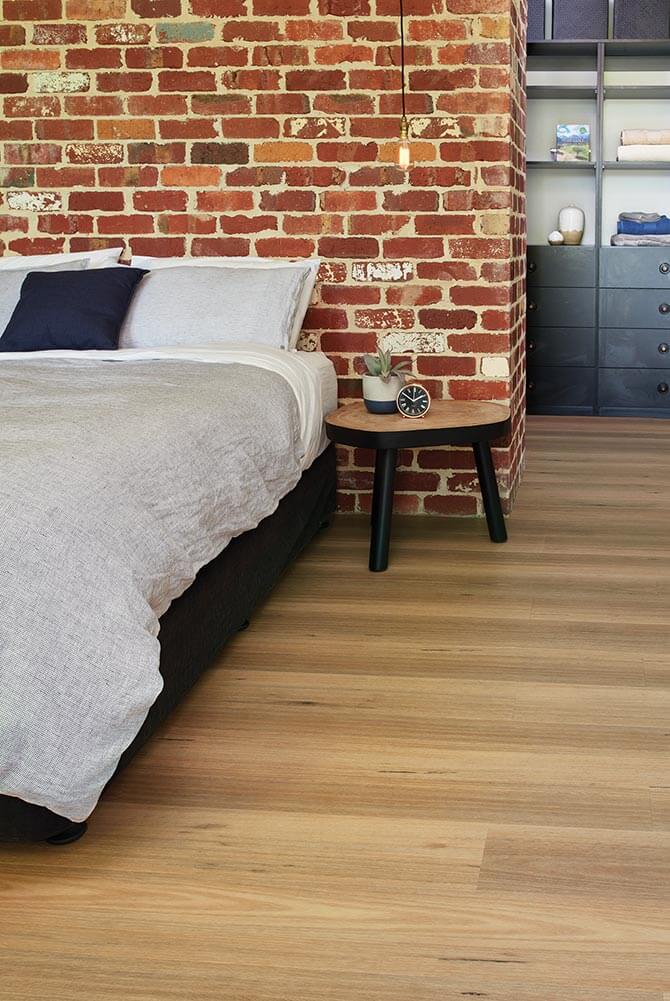 Bedroom with brick wall and wooden floor