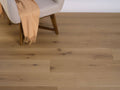 Wooden flooring with a chair and beige blanket in the background
