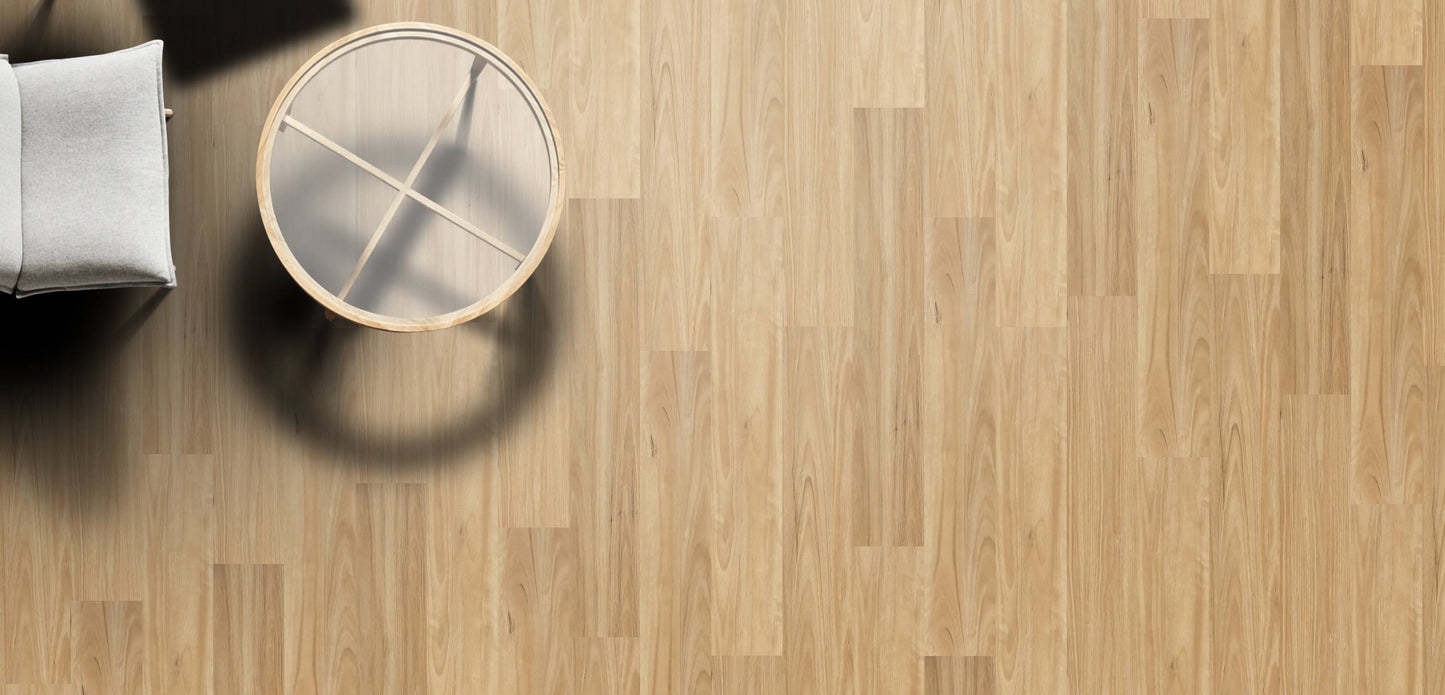 Wooden floor with a small round stool and a white cushioned chair.