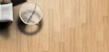 Wooden floor with a round metallic object casting a shadow