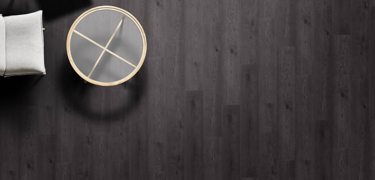 Round gray coaster with gold accents on a dark wooden surface