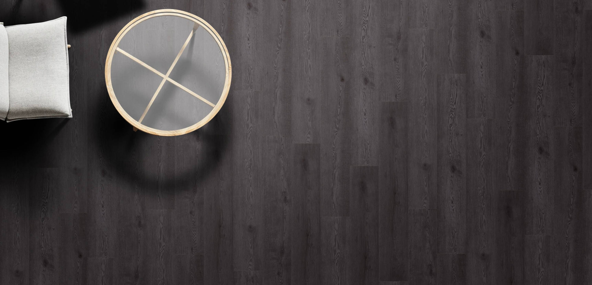 Round gray coaster with gold accents on a dark wooden surface