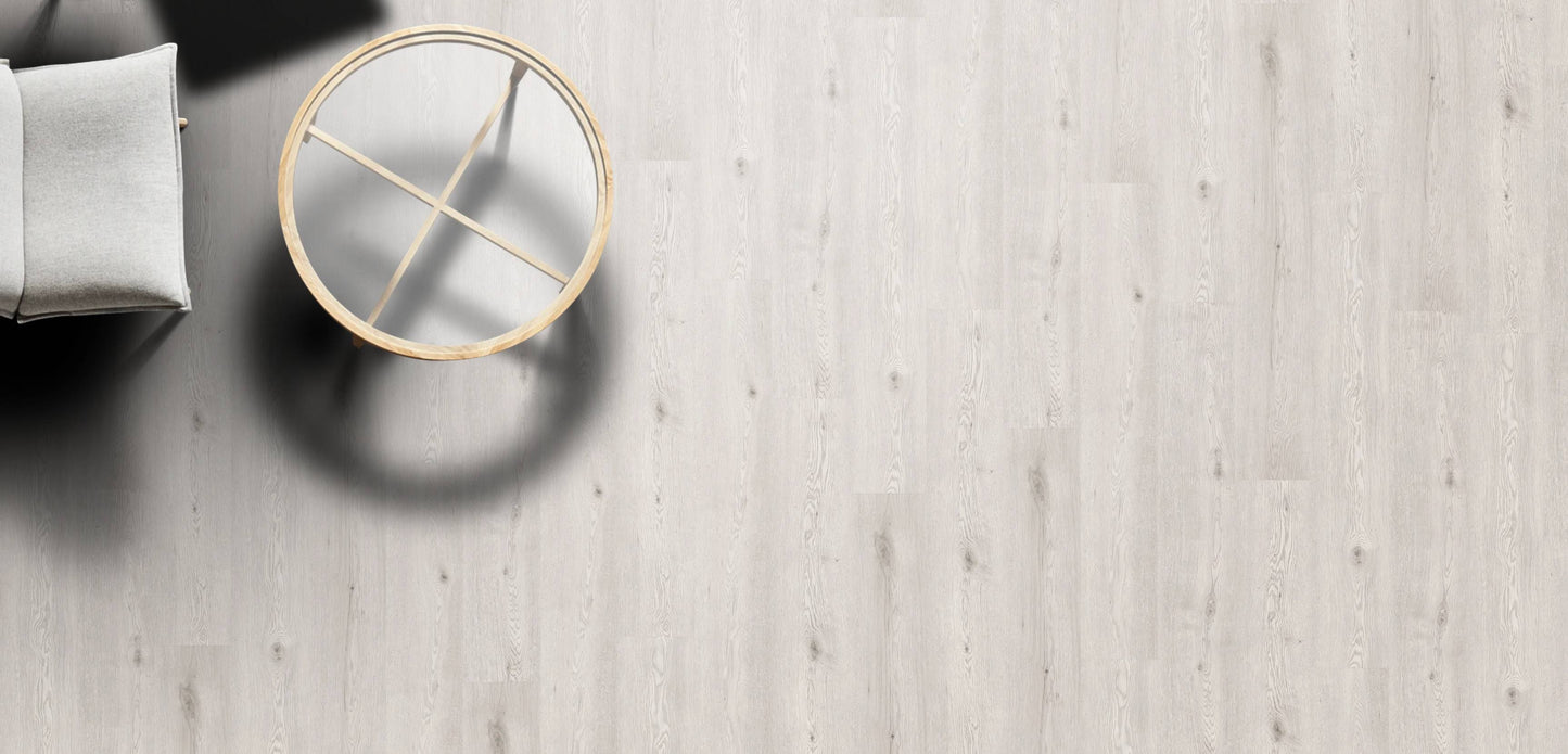 Round gold mirror on a light wooden floor with a neutral color palette