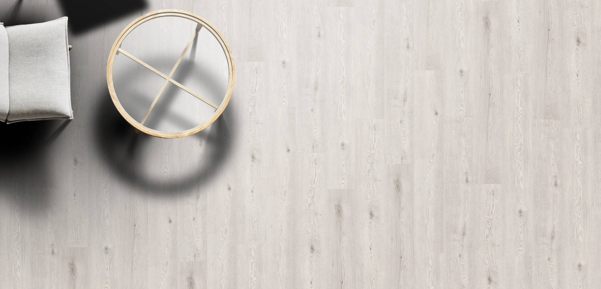 Round gold mirror on a light wooden floor with a neutral color palette