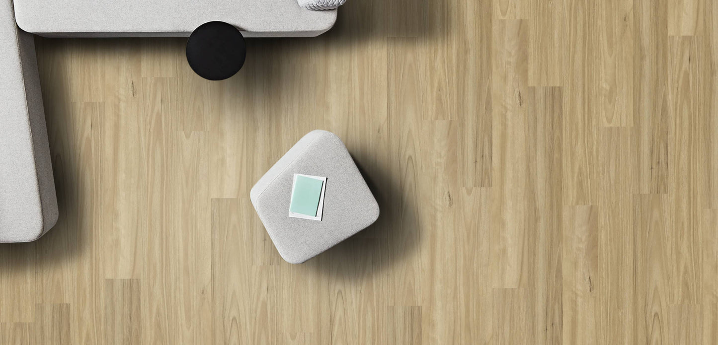 Small gray cube with a green label on a wooden floor