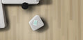 Small gray cube with a green label on a wooden surface