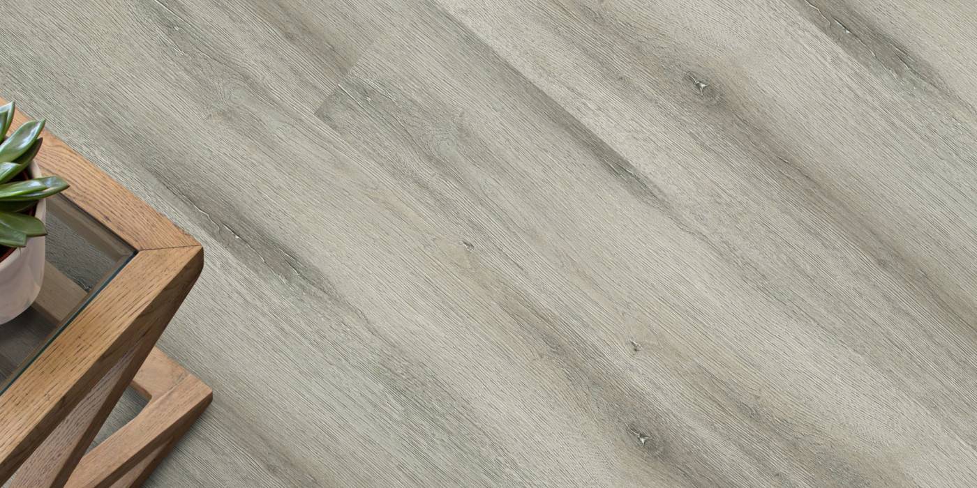 Close-up of a wooden coffee table with a plant on a light wood floor.