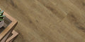 Close-up of wooden flooring with a plant and wooden furniture corner.