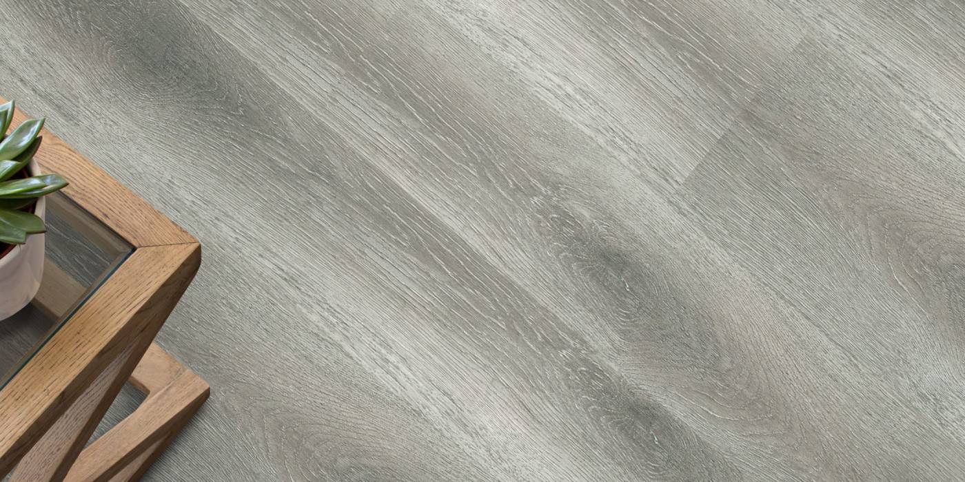 Gray tiled floor with a wooden side table and plant