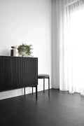 Modern interior with a black radiator and white curtains